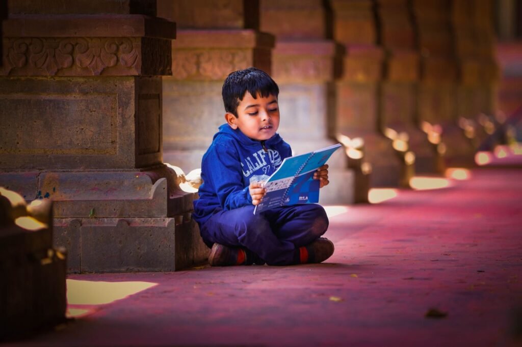 pexels photo 33947140 A young boy sits and reads a book indoors in a traditional Indian architectural setting in Indore.