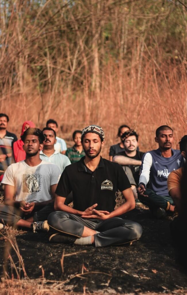 pexels photo 3957803 A diverse group meditating outdoors in a natural setting in Thrissur, India, promoting peace and relaxation.